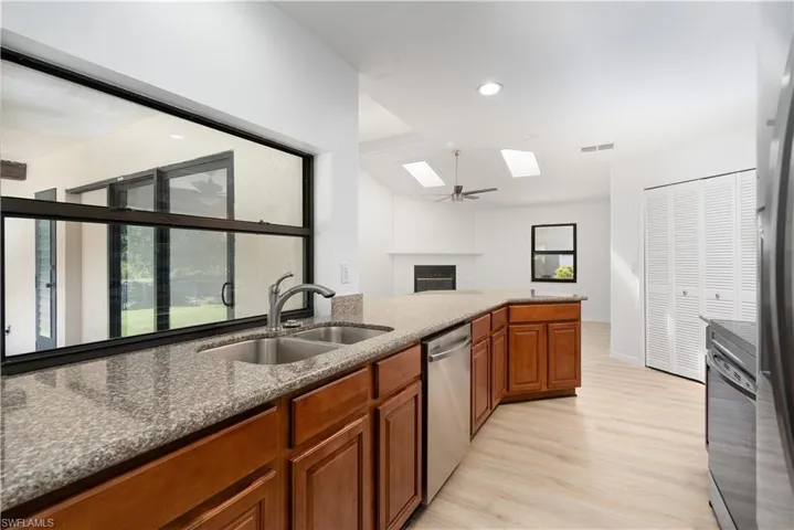 Kitchen featuring a skylight, a fireplace, visible vents, appliances with stainless steel finishes, and a sink