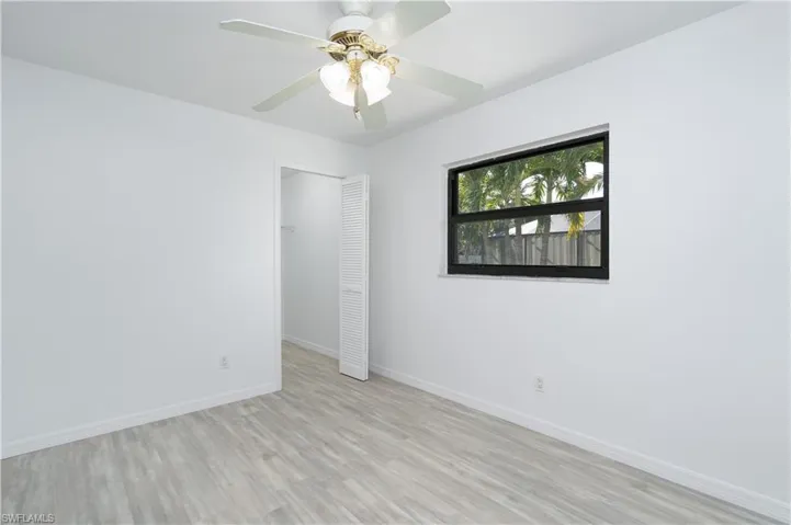 Bedroom 2 featuring ceiling fan, baseboards, and Pergo flooring with closet space. Freshly painted interior.  Would make a nice study, too.