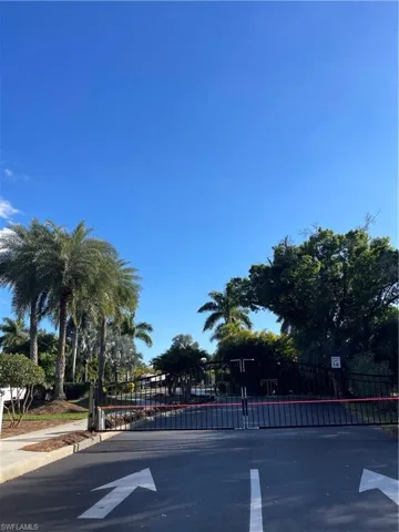View of street with a gated entry, a gate, and curbs