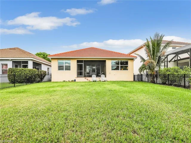 Back of house featuring a lanai and a lawn