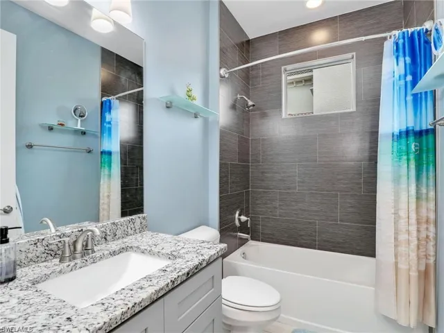 Full bathroom featuring toilet, vanity, and shower / bath combo with shower curtain