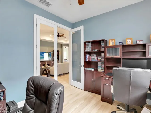 Office area with ceiling fan, light hardwood / wood-style flooring, and french doors