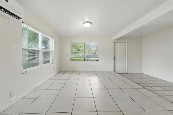 Unfurnished room with a wall mounted air conditioner and light tile patterned floors