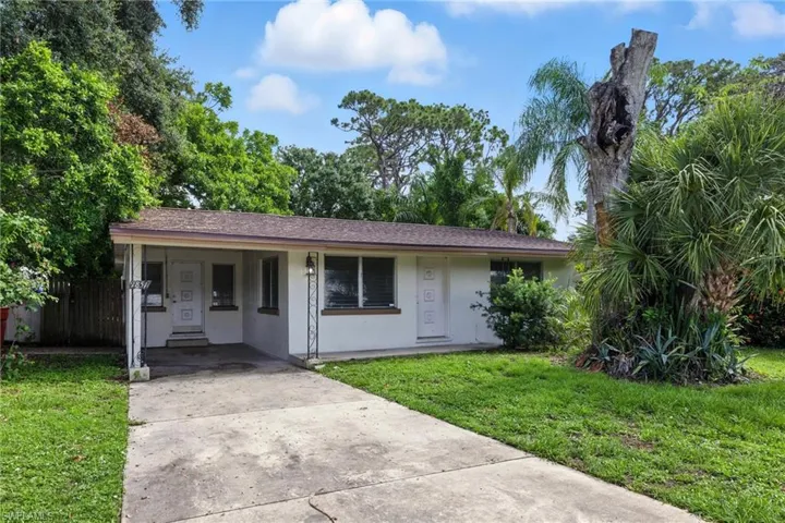 Ranch-style house featuring concrete driveway, an attached carport, and stucco siding
