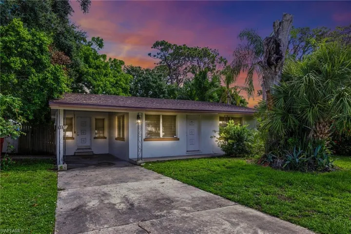 Single story home featuring driveway, a carport, stucco siding, and covered porch
