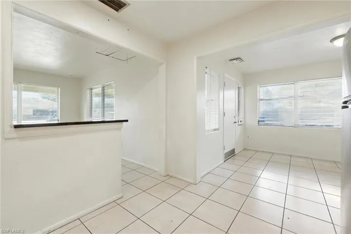 Spare room featuring light tile patterned floors and baseboards