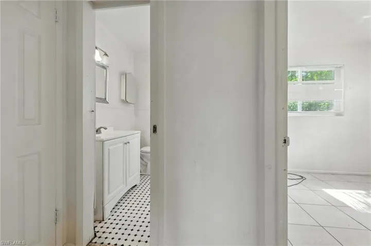 Hallway with baseboards and light tile patterned flooring