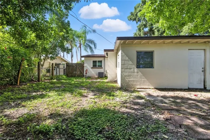 Back of property featuring a gate and concrete block siding