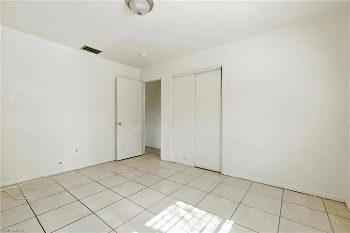 Unfurnished bedroom featuring light tile patterned floors and a closet
