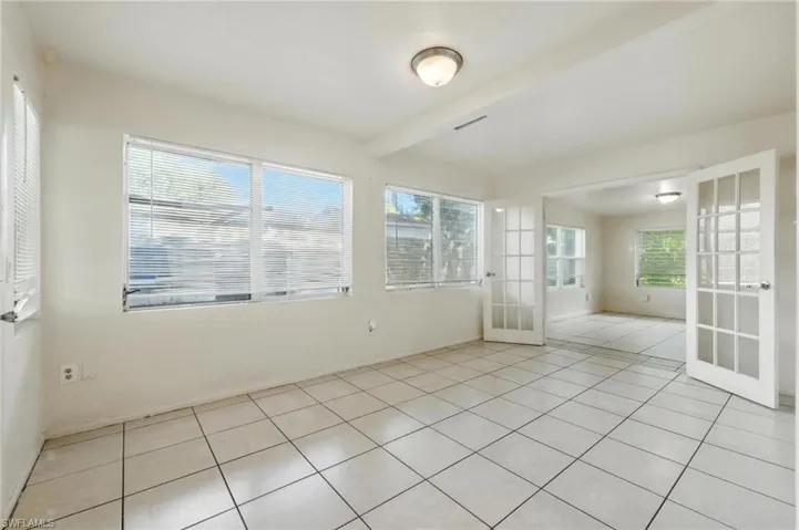 Unfurnished sunroom featuring french doors