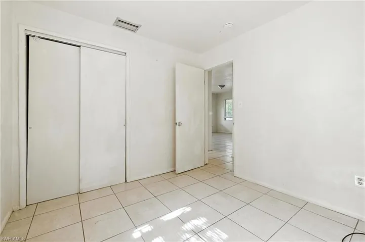 Unfurnished bedroom featuring light tile patterned floors and a closet