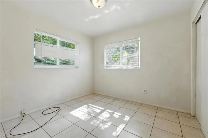 Empty room featuring light tile patterned flooring and baseboards