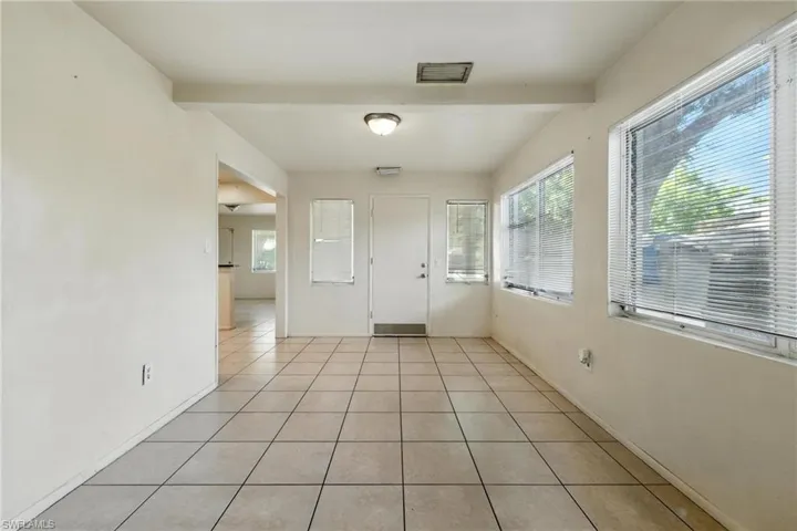 Foyer entrance with beam ceiling and light tile patterned floors