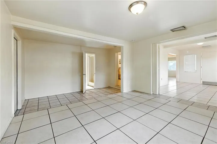 Unfurnished room featuring light tile patterned floors and baseboards