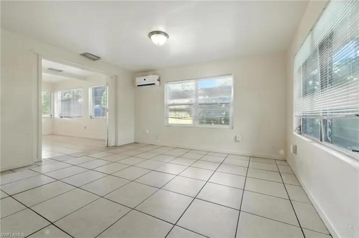 Spare room with light tile patterned floors and a wall mounted air conditioner
