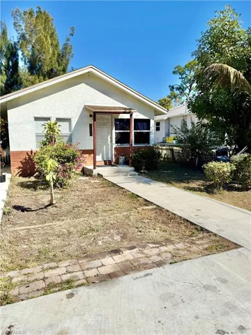 Bungalow-style house with stucco siding and brick siding
