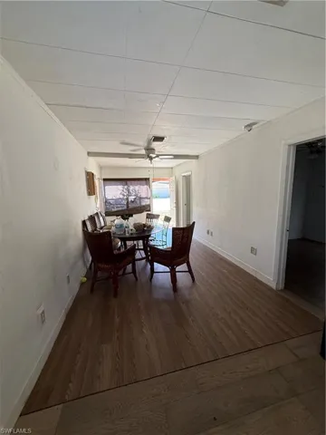 Dining space featuring dark wood-style flooring and ceiling fan