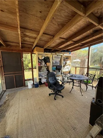 Carpeted office space with plenty of natural light and wooden ceiling