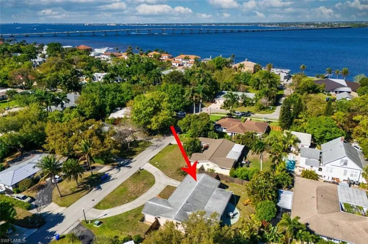 Aerial perspective of suburban area featuring a notable bridge and the river.