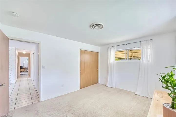 Third bedroom with light colored carpet and a closet
