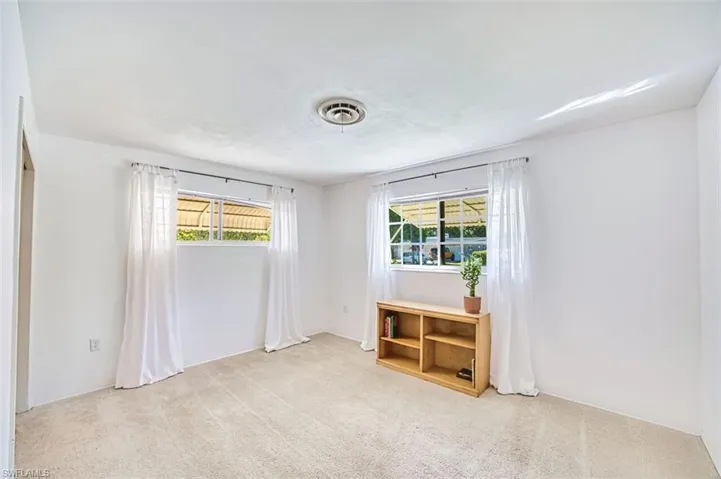Third bedroom with healthy amount of natural light and light carpet