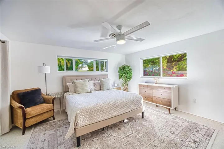 Bedroom with a ceiling fan and dark speckled floor