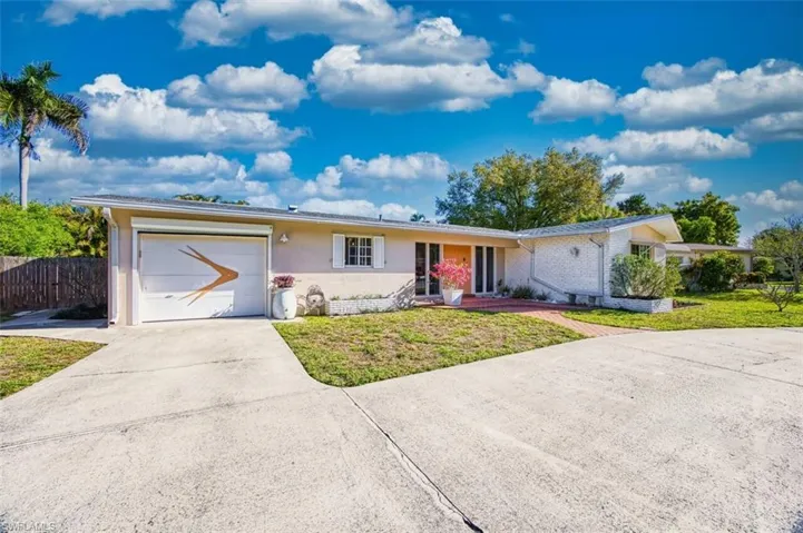 Ranch-style home with concrete driveway, an attached garage, a front yard, and stucco siding