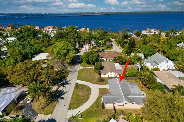 Aerial perspective of suburban area with a notable bridge and the river.