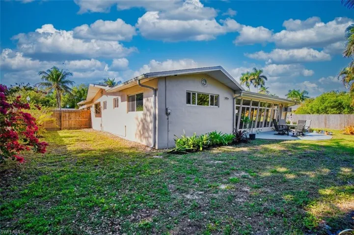 View of side of property featuring a fenced backyard, a sunroom, stucco siding, and a patio area. Plenty of room to add a pool.