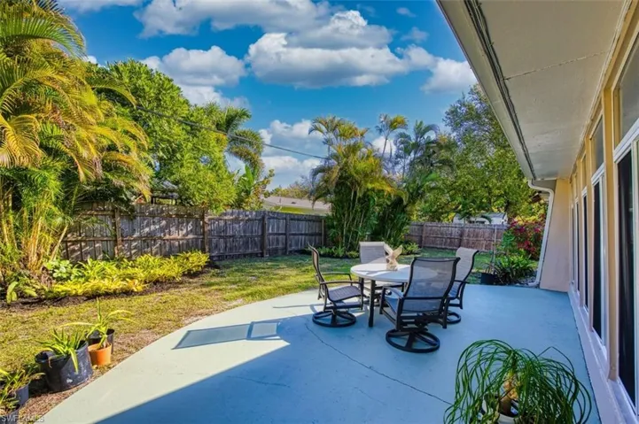 Fenced backyard with a circular patio area and outdoor dining space