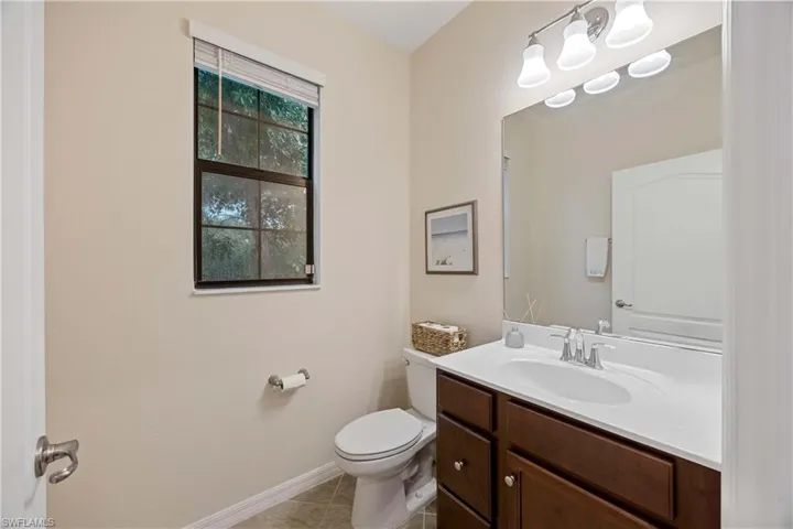 Half bath featuring vanity and tile patterned flooring
