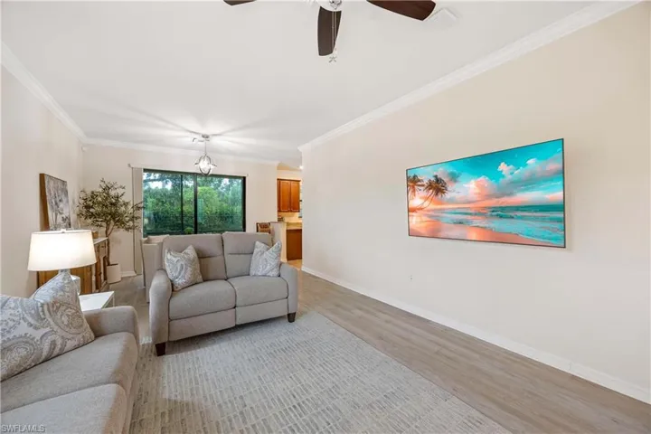 Living area featuring light wood-type flooring, crown molding, and a ceiling fan