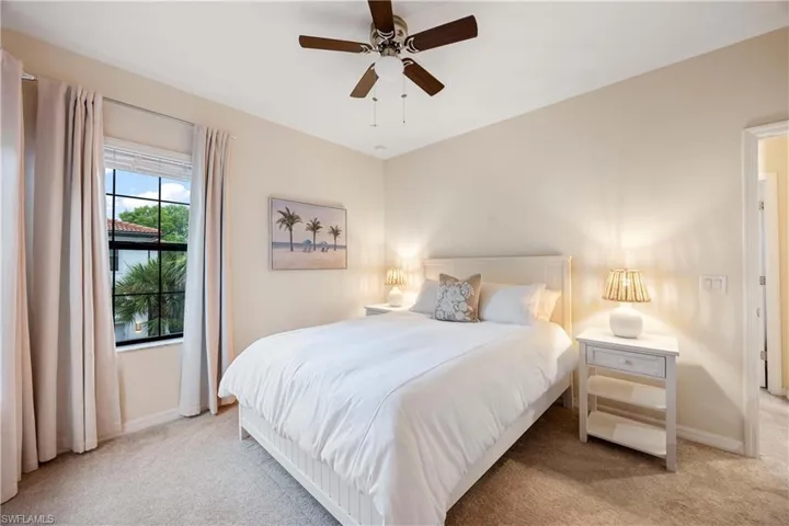 Bedroom with light carpet and a ceiling fan