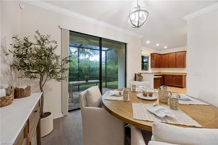 Dining room featuring ornamental molding, healthy amount of natural light, light wood-type flooring, recessed lighting, and a chandelier