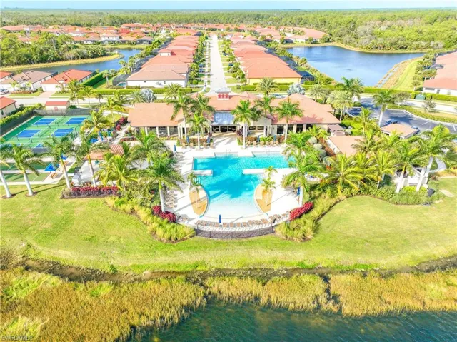 Aerial view of residential area with a large body of water and a pool area