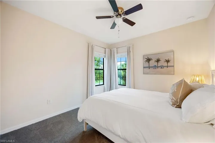 Carpeted bedroom featuring baseboards and a ceiling fan