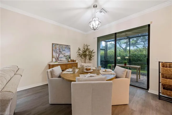 Dining area featuring wood finished floors and crown molding