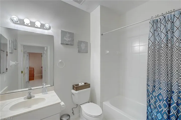 Full bathroom featuring shower / bath combination with curtain and vanity