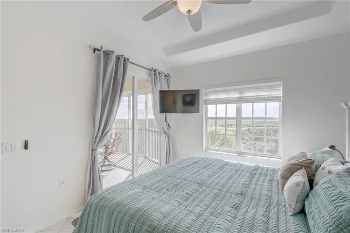 Bedroom with access to exterior, ceiling fan, and light tile patterned flooring