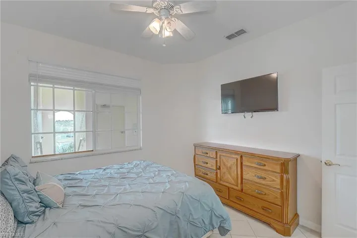 Bedroom with light tile patterned flooring and a ceiling fan