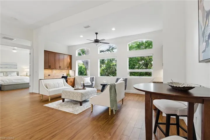 The living room space is ideal conversation spot with a home office space to the side and bar area on the other side