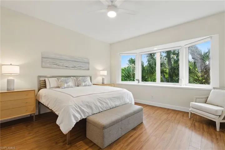 The primary bedroom features a spacious suite with a sitting area and a large bay window expanse of the preserve in back