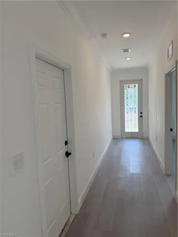 Corridor featuring ornamental molding and wood finished floors