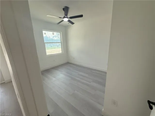 Empty room featuring light wood-style flooring and a ceiling fan