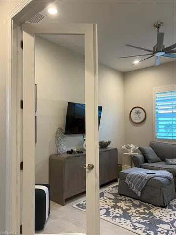 Den with ceiling fan and glass french doors
