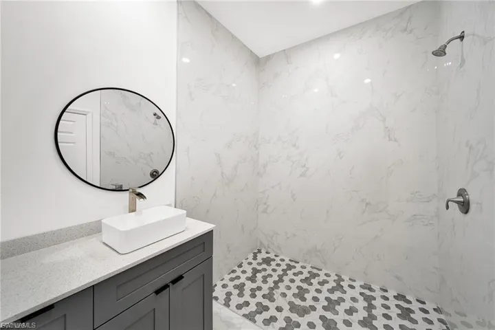 Bathroom with a marble finish shower and vanity