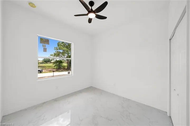 Unfurnished bedroom featuring marble finish flooring, a closet, and ceiling fan