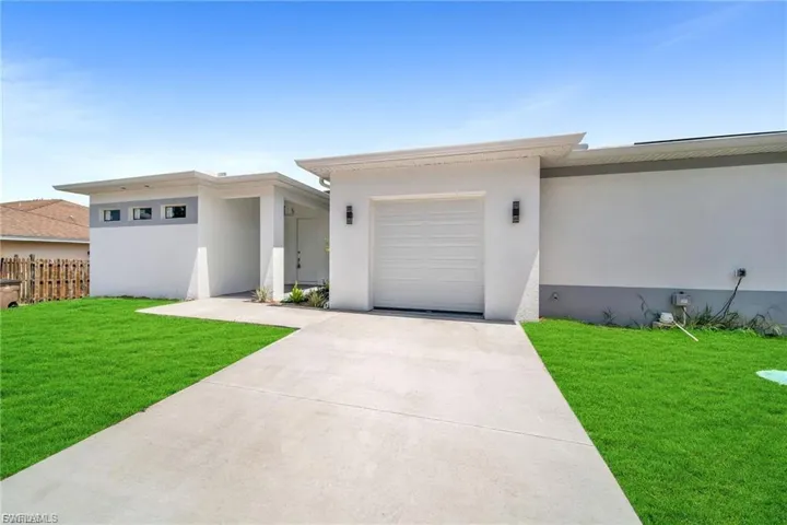 View of front of home with stucco siding and driveway
