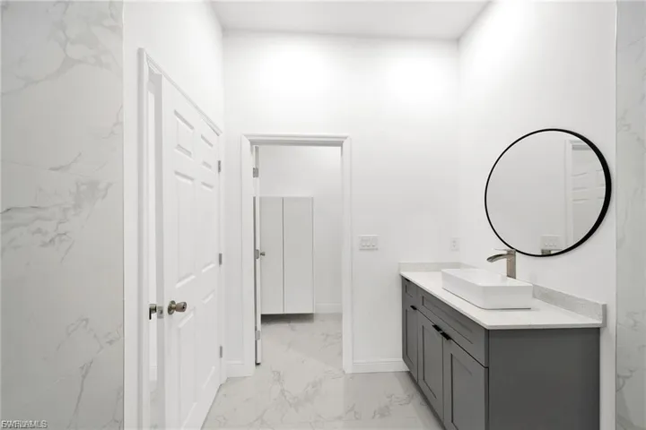 Bathroom featuring light marble finish floors and vanity
