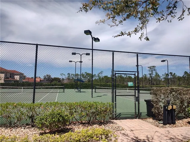 View of tennis court featuring a gate